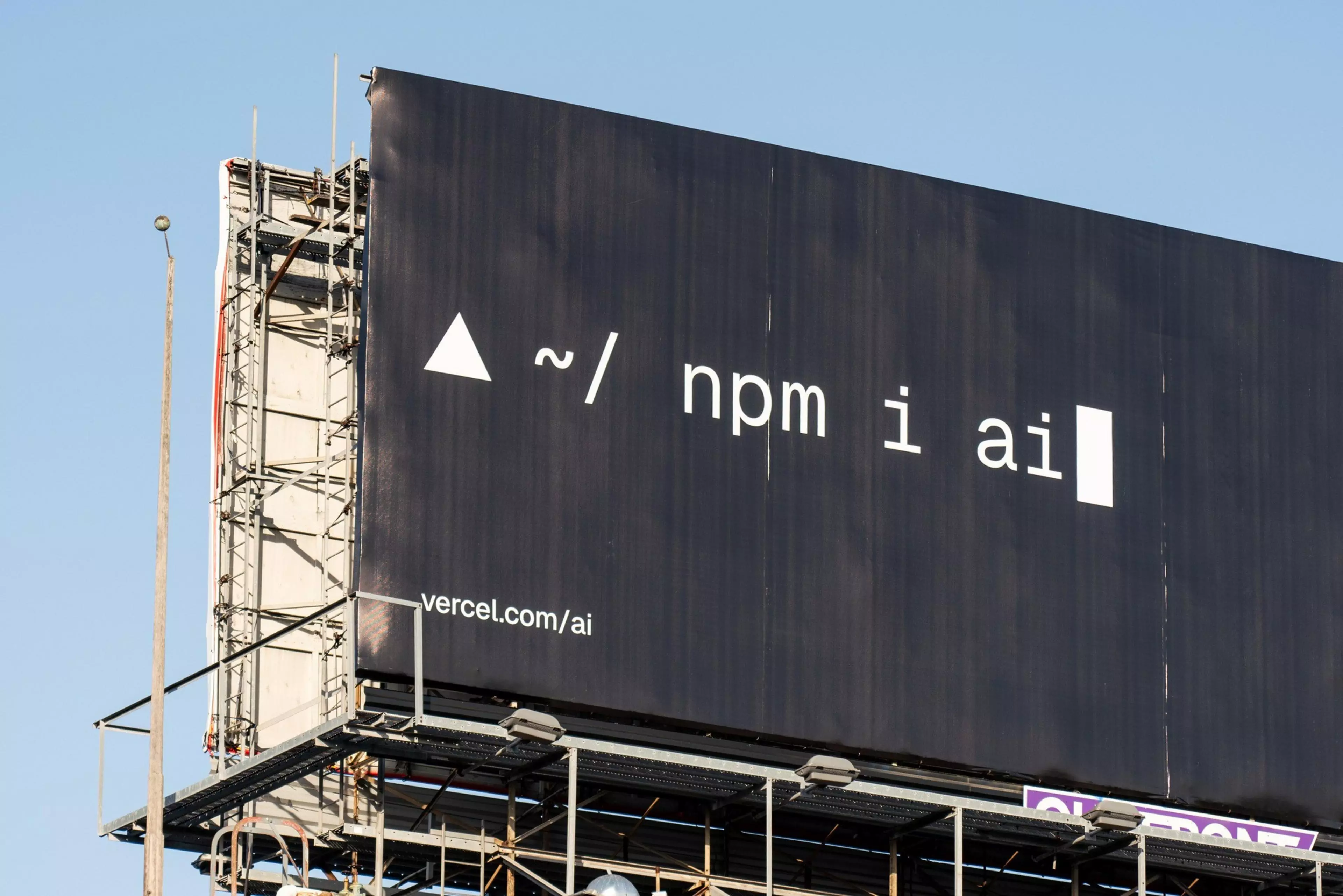 Highway billboard showing Vercel's npm i ai command in terminal style